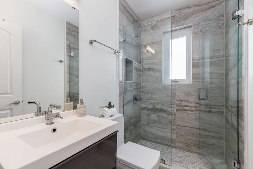 Douche vitrée aux murs de pierre avec veinures