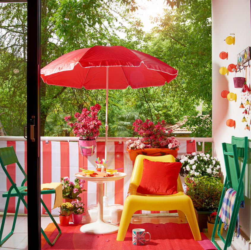 Backyard wood deck with colourful decor, yellow chair and table