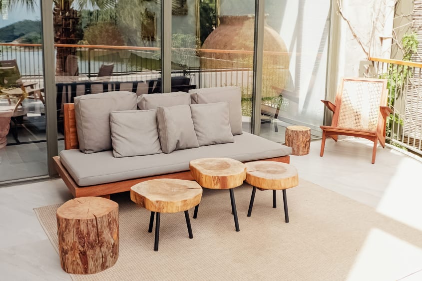 Indoor low couch and wooden benches displayed on outdoor deck