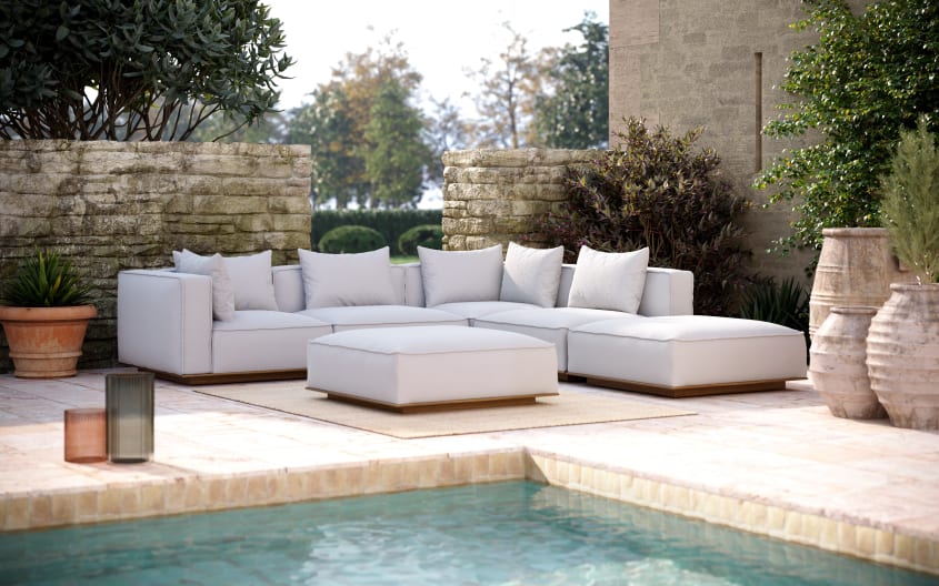 Large comfortable pale gray modular sofas displayed on an outdoor deck, swimming pool and terracotta amphoras