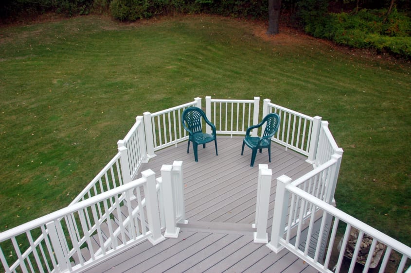 Hexagonal multi-level deck with white rail and two green chairs
