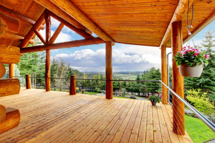 Log cabin house with rustic deck overlooking trees