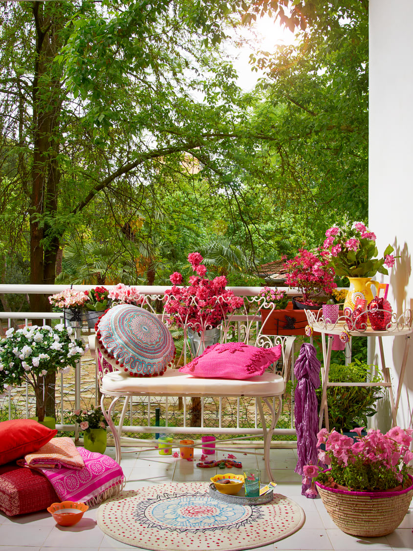 Backyard wood deck with colourful decor, chair, plants and rug