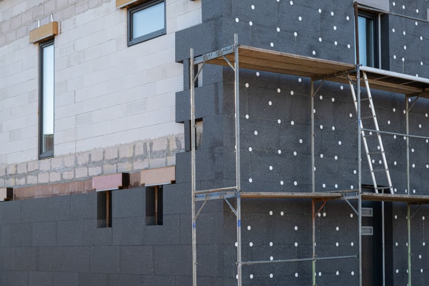 House construction in progress with thermal insulation of the exterior wall using layers of modern materials