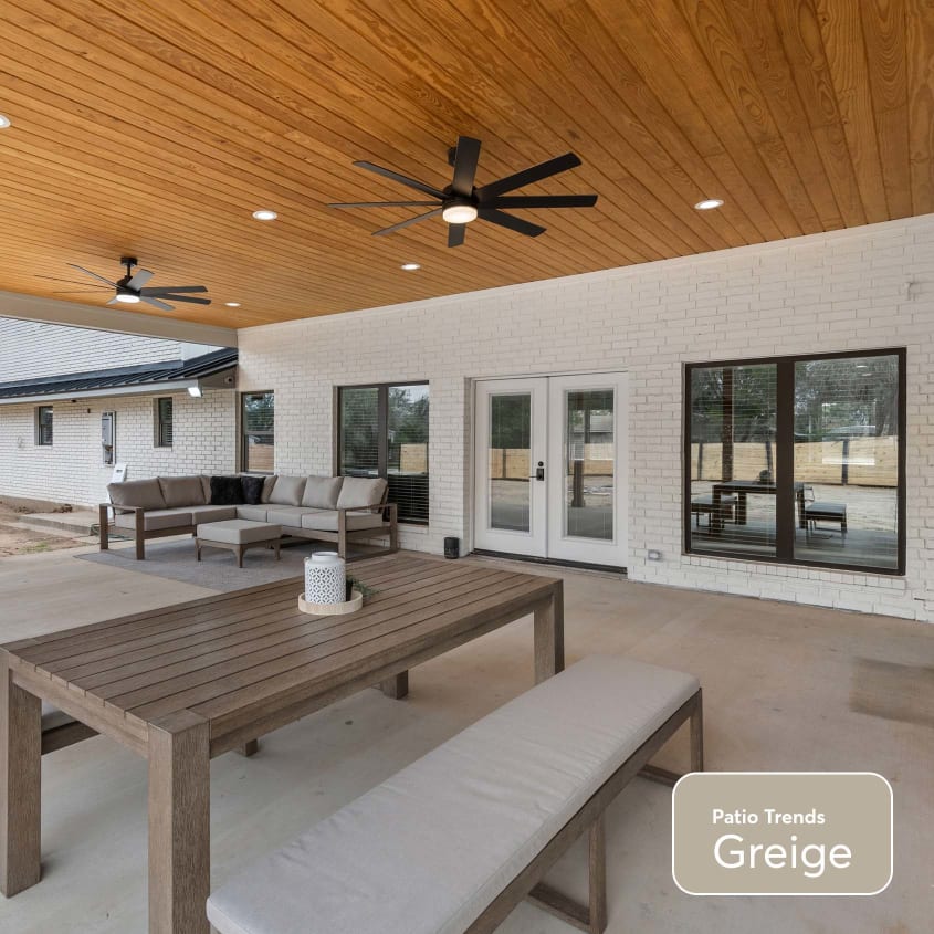 Large grey cement patio with outdoor dining furniture, wooden roof and ceiling fans