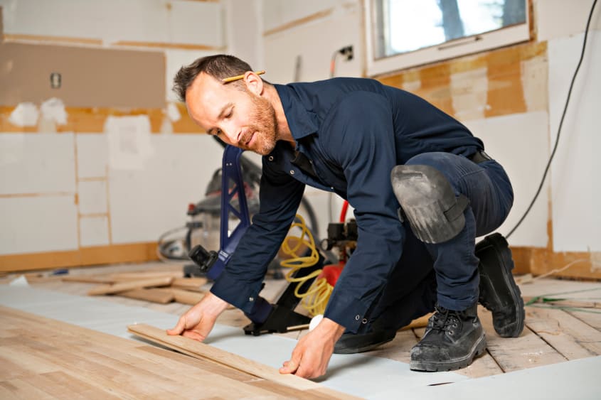 Entrepreneur qualifié installant un plancher de bois franc
