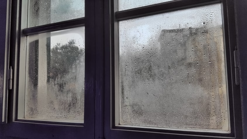 Condensation et buée entre deux vitres d'une fenêtre résidentielle