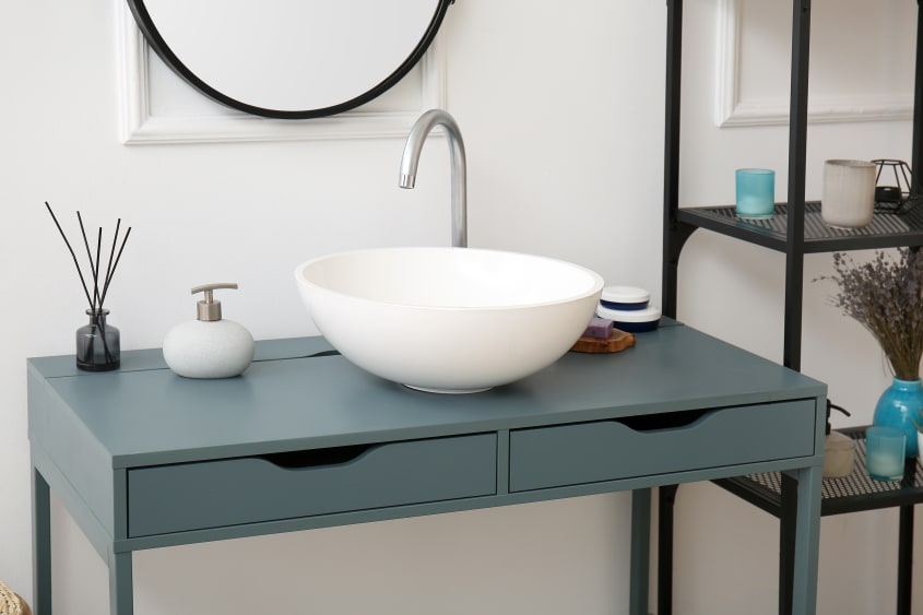 Sculptural brushed-nickel fixtures on a vessel sink