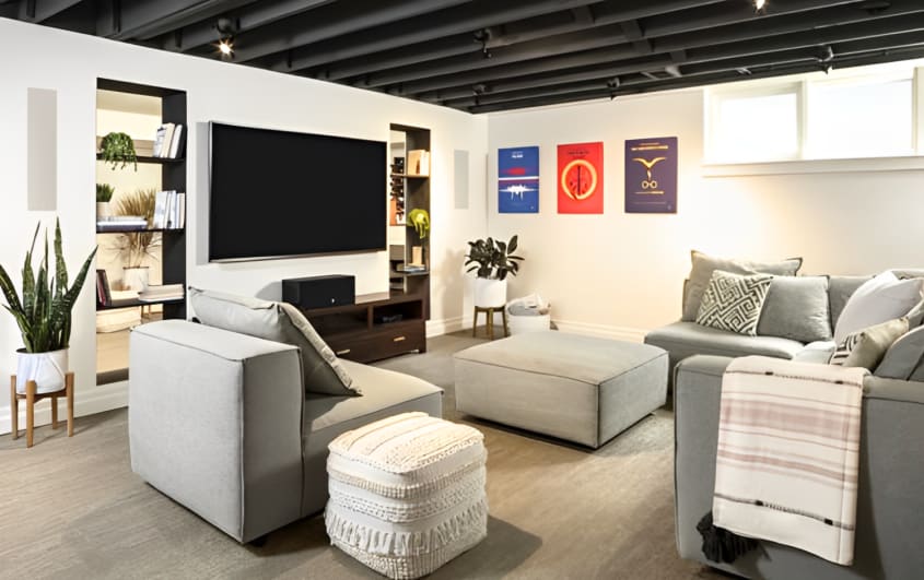 sous-sol avec éclairage de style industriel dans salon avec sofas gris