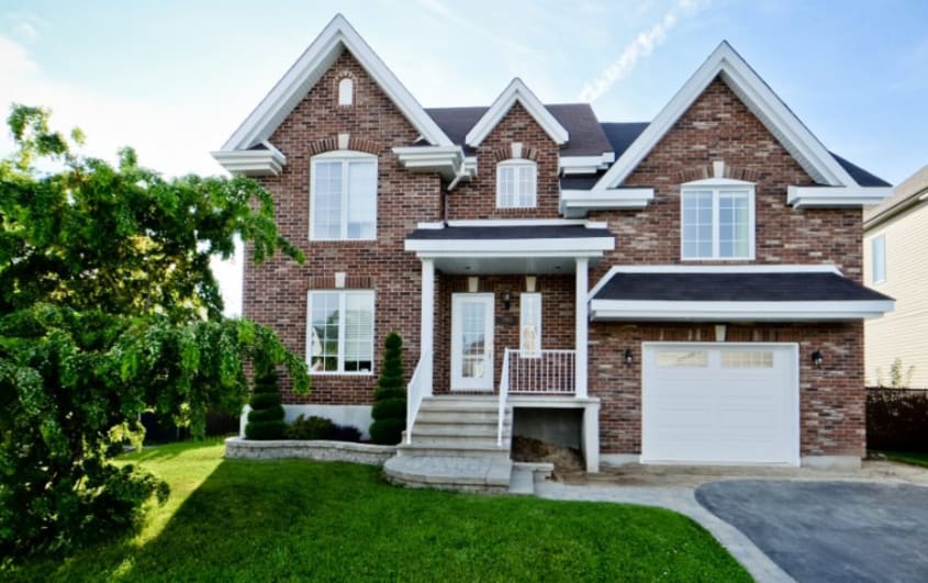 front of brick house with garage and storey addition