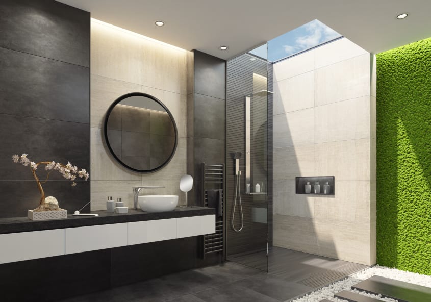 Salle de bain luxueuse avec douche italienne, murs en travertin, plancher en dalles en ardoise, puits de lumière, mur végétal en mousse et section de plancher en galets décoratifs blancs