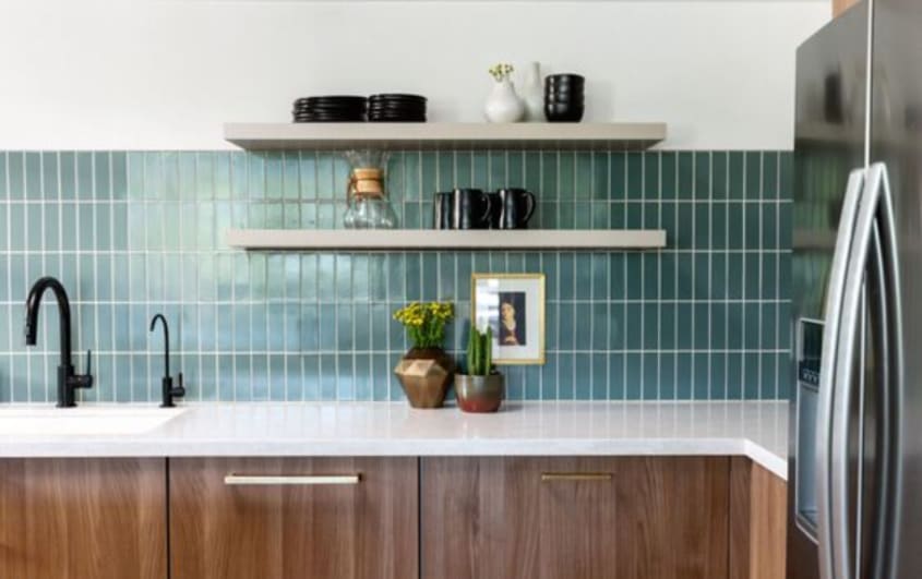 Kitchen with blue-green backsplash tiles, wooden cabinets and white counter