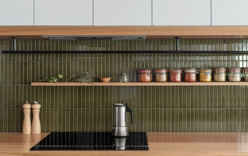 Kitchen with olive green backsplash and white grout and wooden counter