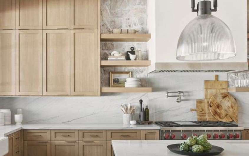 Kitchen with light wood cabinets and white marble backsplash