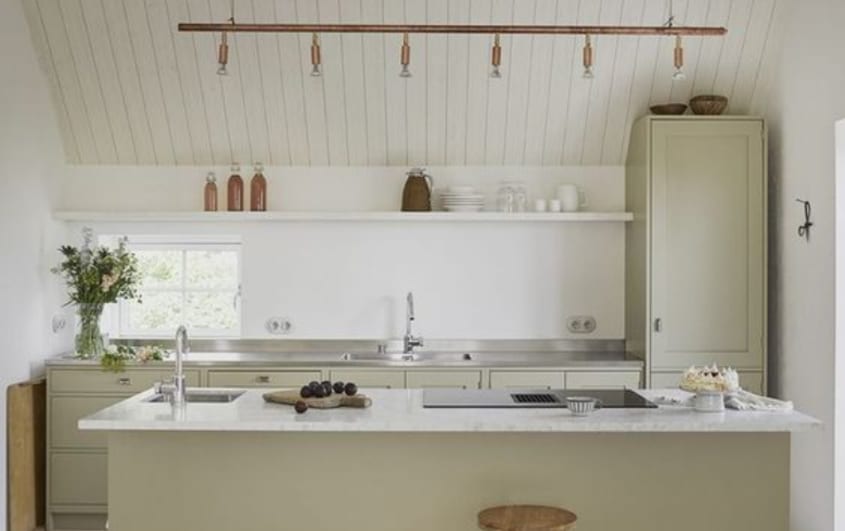 kitchen with green cabinets and island with white paint as backsplash