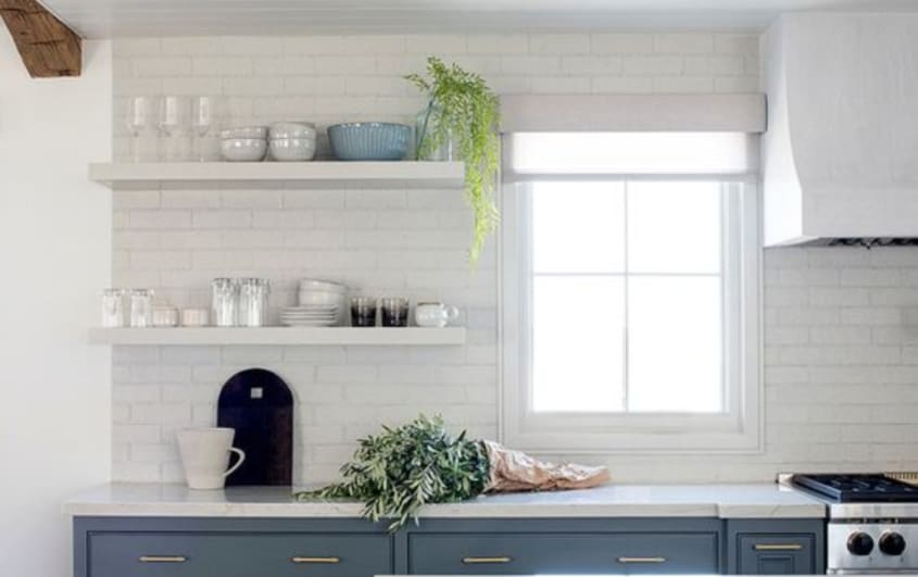 white kitchen with exposed white brick as a backsplash
