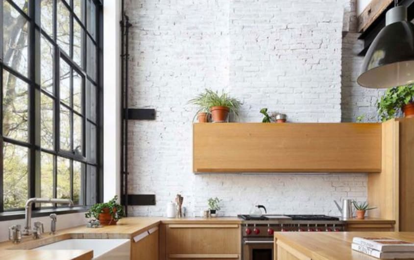 Open concept kitchen with wooden cabinets and white brick