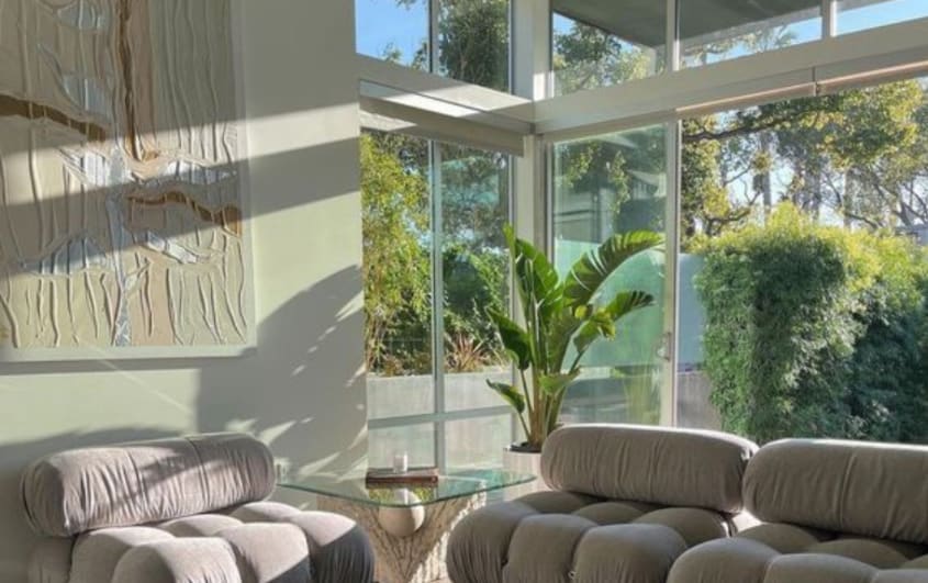 Neutral toned living room with floor to ceiling windows in house extension