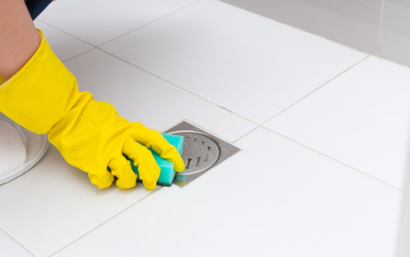 bathroom floor drain being cleaned to avoid hidden bathroom problems