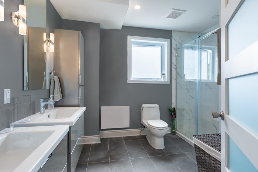 salle de bain moderne grise avec 2 vanités suspendues et douche vitrée