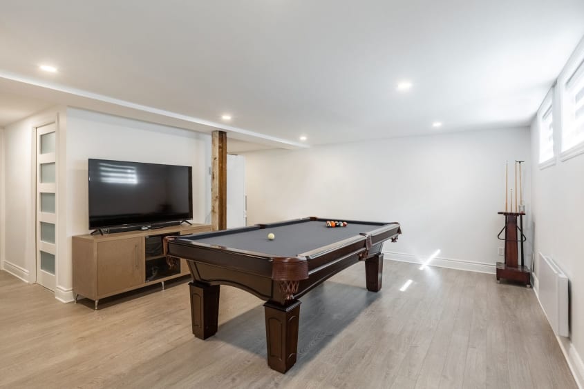 rénovation d'un sous-sol moderne avec table de billard et téléviseur