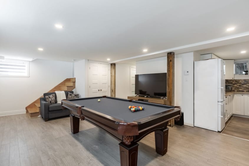 aménagement de sous-sol avec table de billard et téléviseur