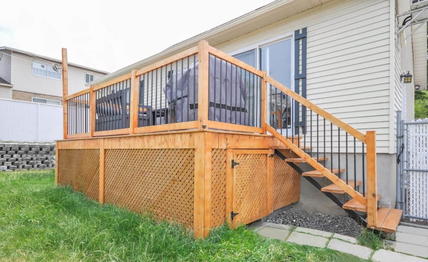 Patio en bois traité teint avec rampes en cèdre et barreaux en métal