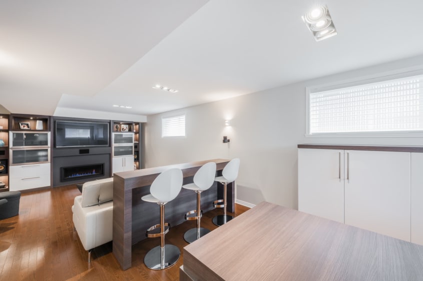 aménagement de sous-sol avec comptoir lunch et meubles sur mesure - Style contemporain
