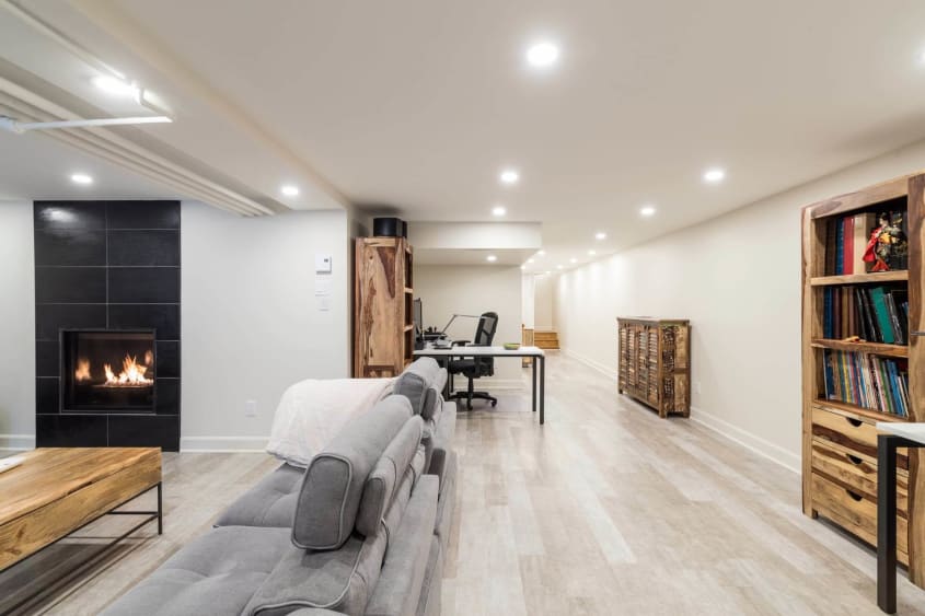 Belle décoration avec foyer dans un sous-sol aménagé par un Entrepreneur Vérifié à 360°