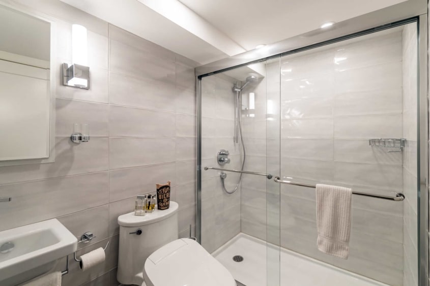 Salle de bain contemporaine renovation sous-sol avec lavabo blanc autoportant, bain-douche et céramique grise pâle au mur