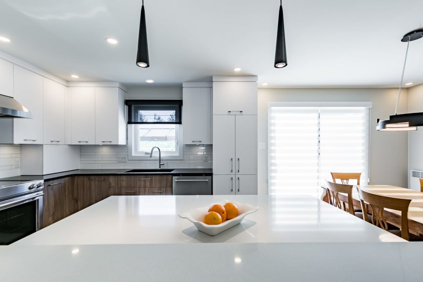 cuisine design deux tons avec îlot et comptoirs en quartz