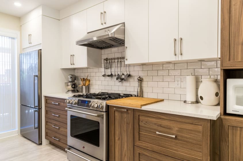 cuisine 2 couleurs (brune et beige) avec comptoir en quartz et cuisinière en stainless