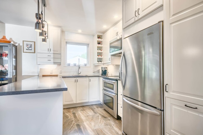 petite cuisine avec armoires blanches et comptoir en quartz gris foncé