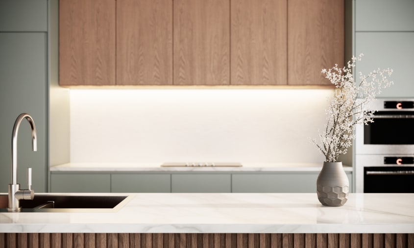 Armoires d’un gris pastel avec pan en bois et comptoir de marbre dans un intérieur rappelant le minimaliste japonais
